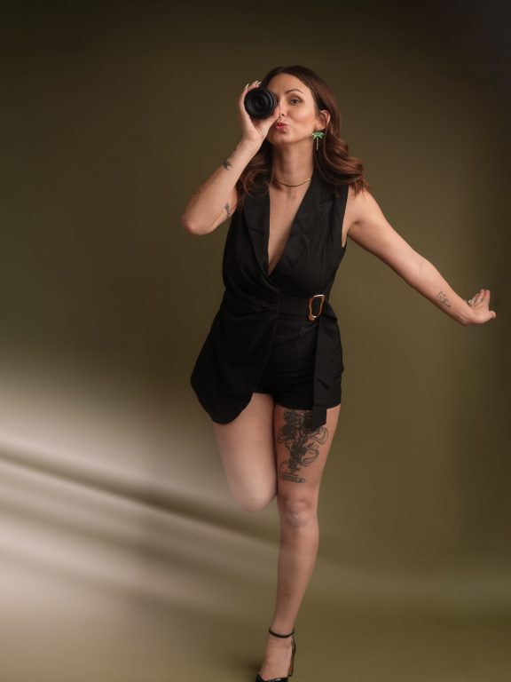 Photographer dancing, with personality and a creative sun flare, showing fun moment and easy relaxing personality..