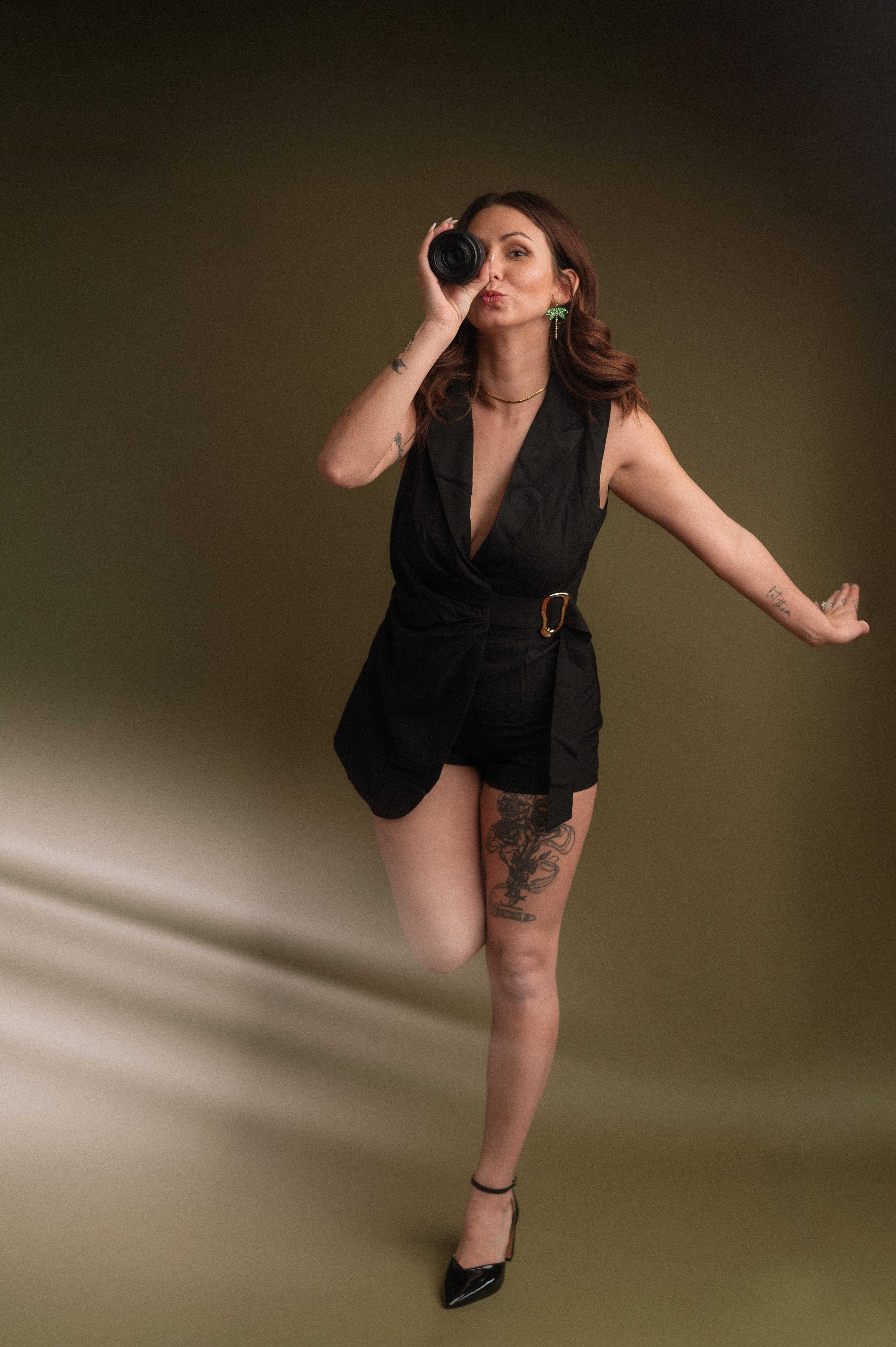 Photographer dancing, with personality and a creative sun flare, showing fun moment and easy relaxing personality..