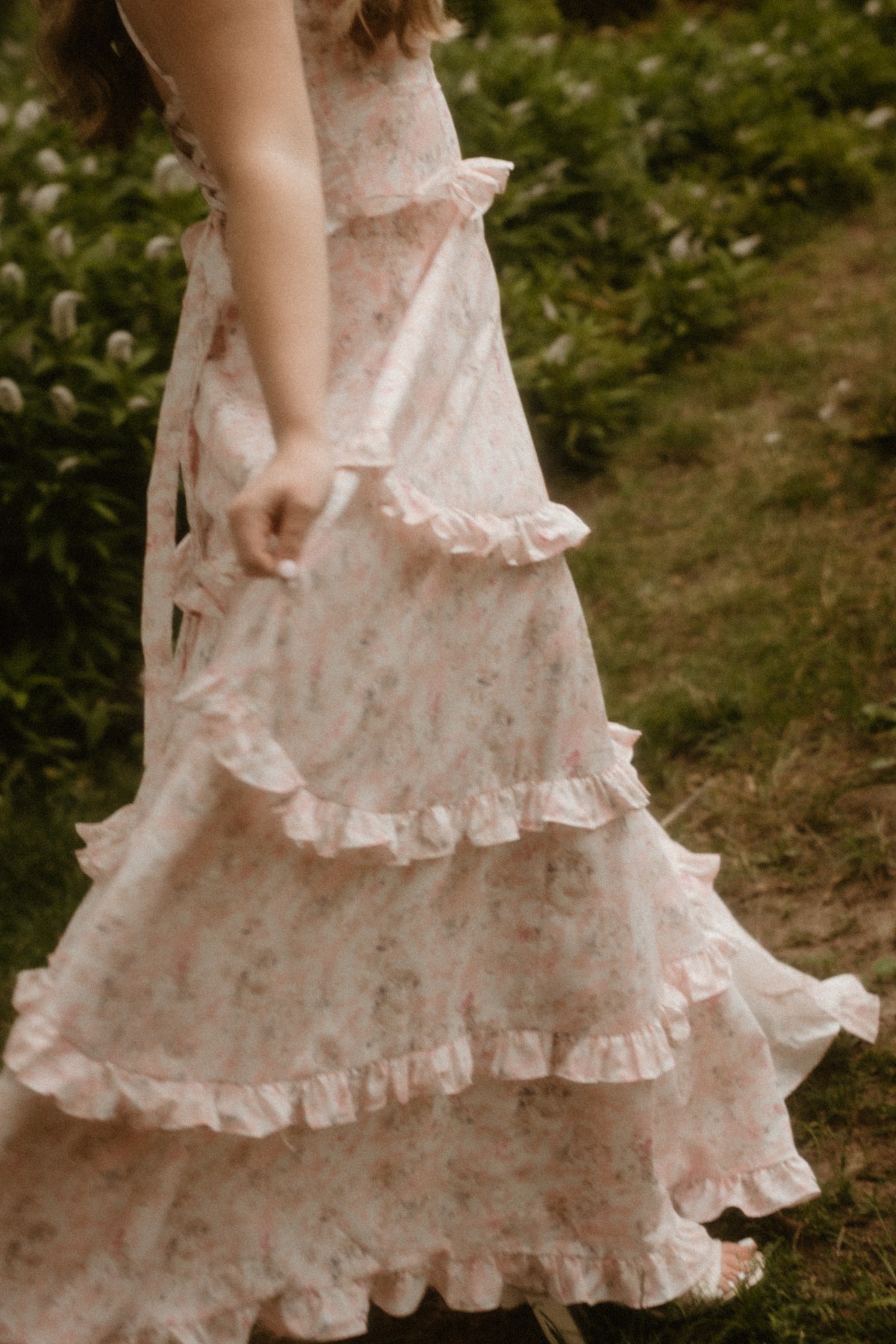 blonde senior twirling in a garden featuring the joslyn castle in omaha nebraska for class of 2027 senior portraits.